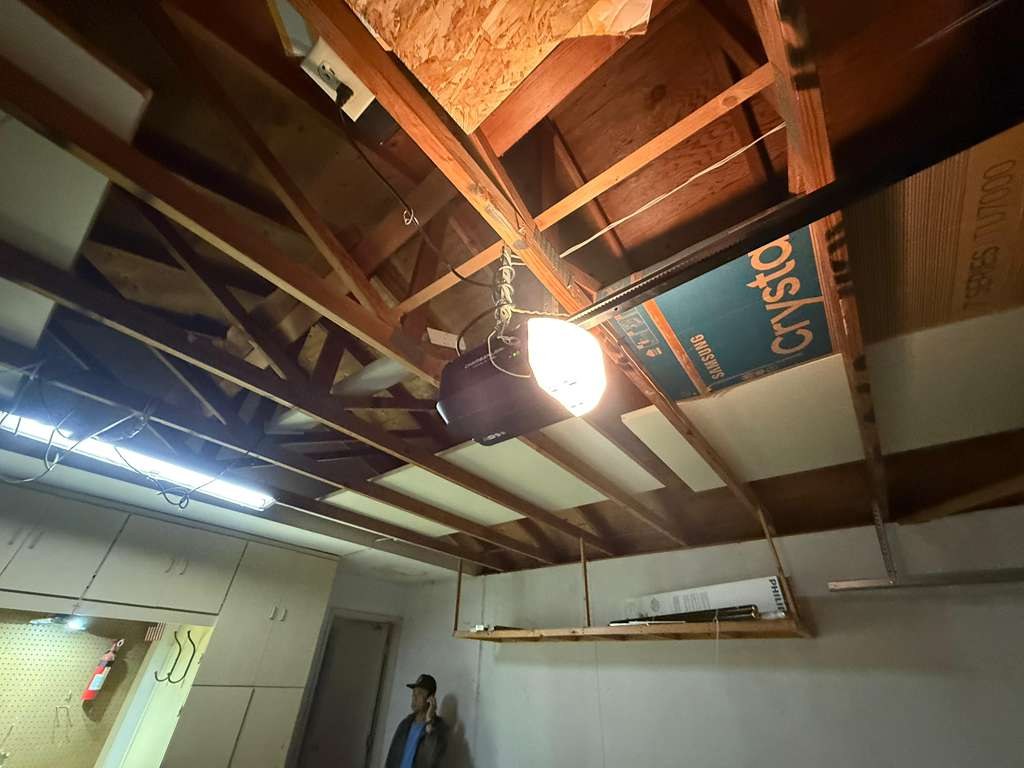 A ceiling-mounted garage door opener motor inside a garage