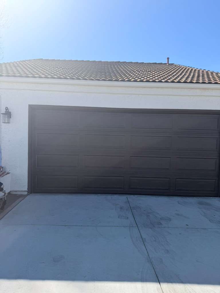 A dark brown raised-panel double garage door