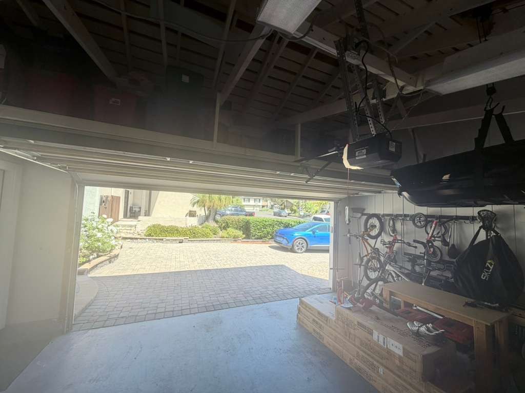 Looking out through an open garage door toward the driveway