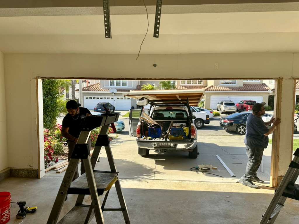A new double garage door being installed, seen from inside
