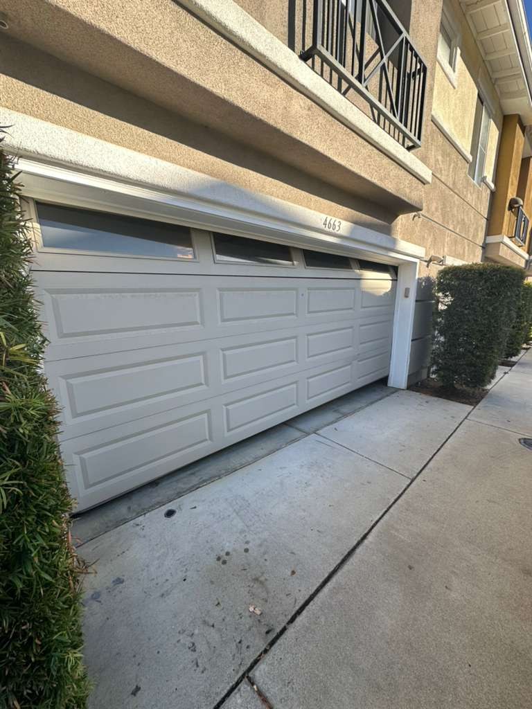 A light gray garage door with windows