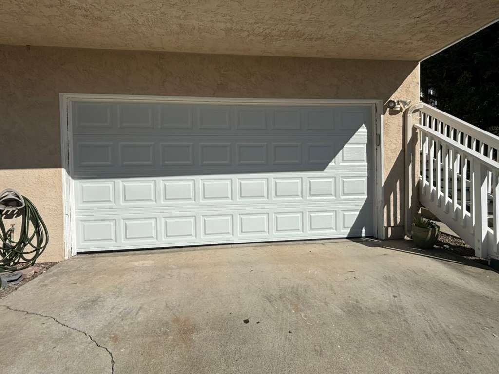 A white raised-panel double garage door