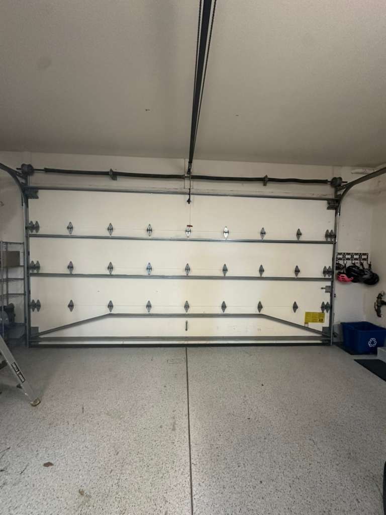 The interior tracks of a white sectional garage door