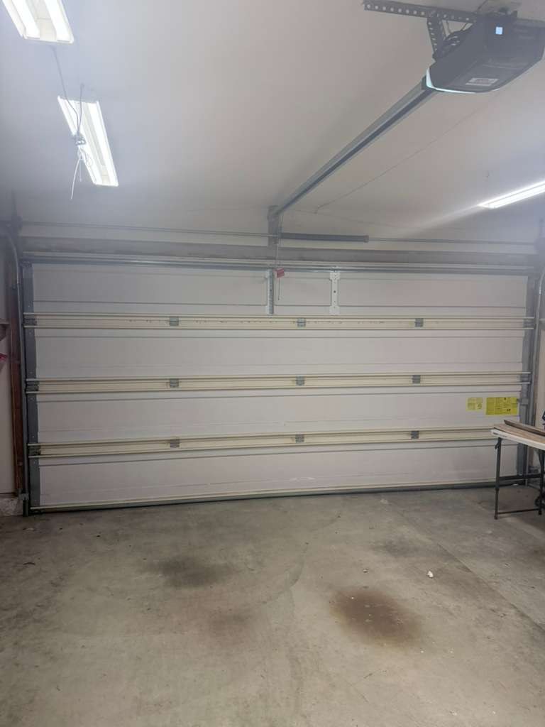A white sectional garage door from inside the garage