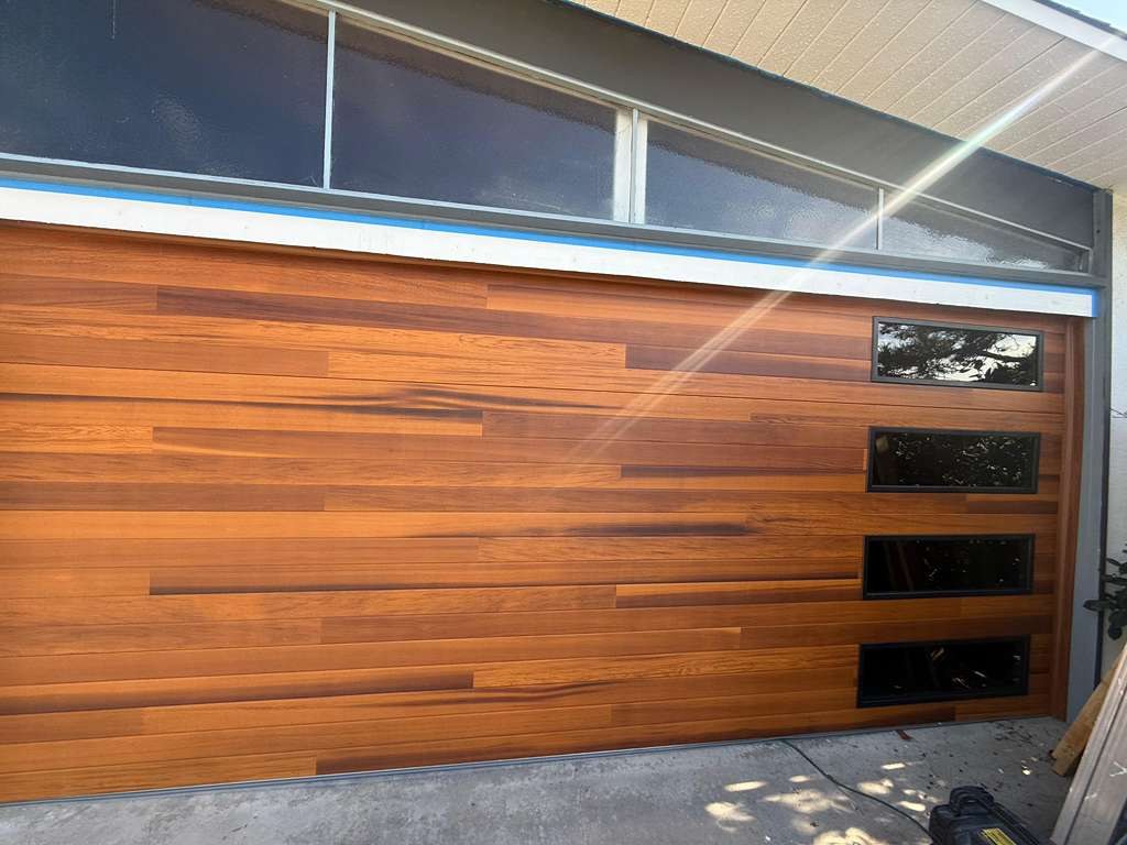 A wood plank garage door with side windows